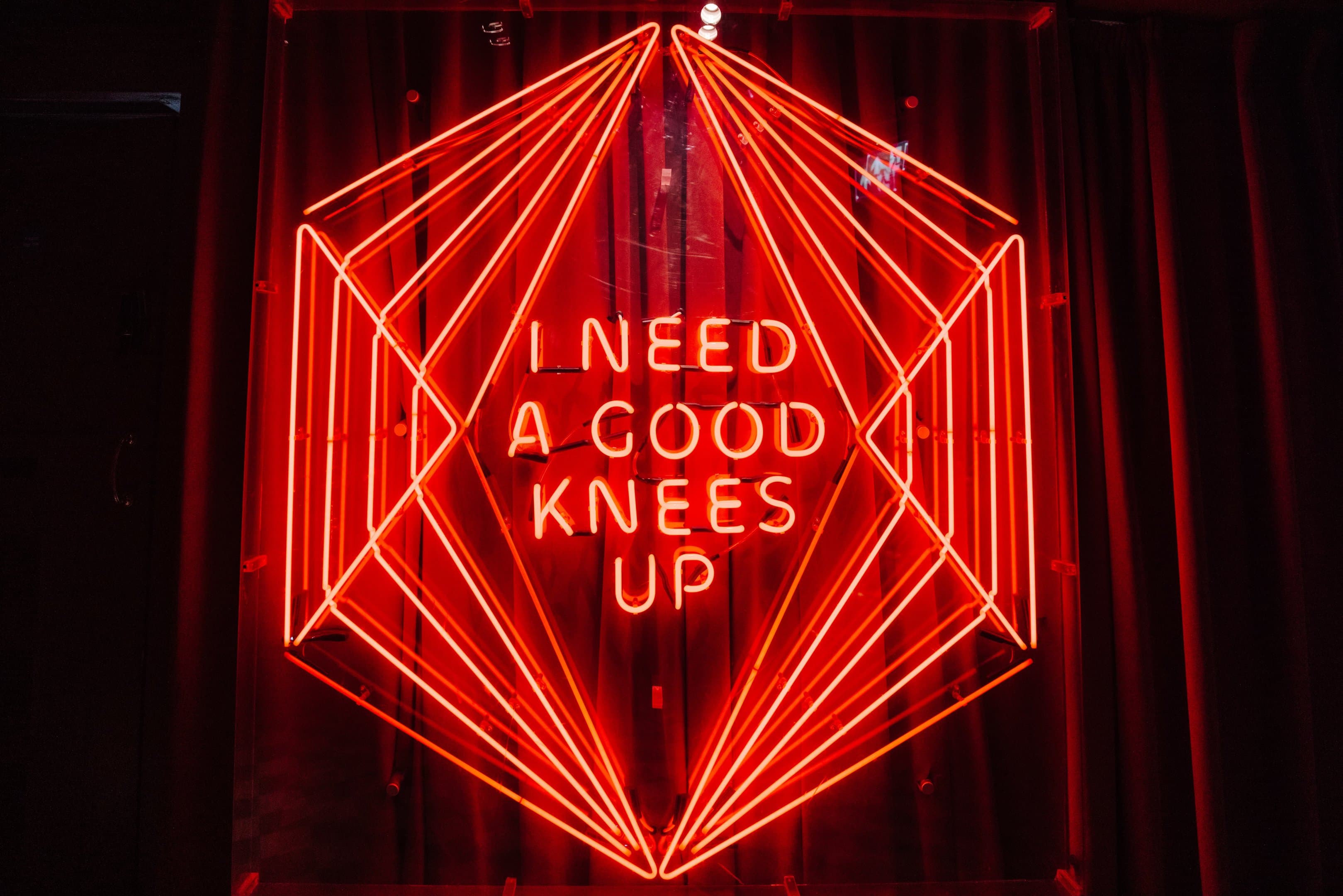 Neon sign saying I need a good knees up