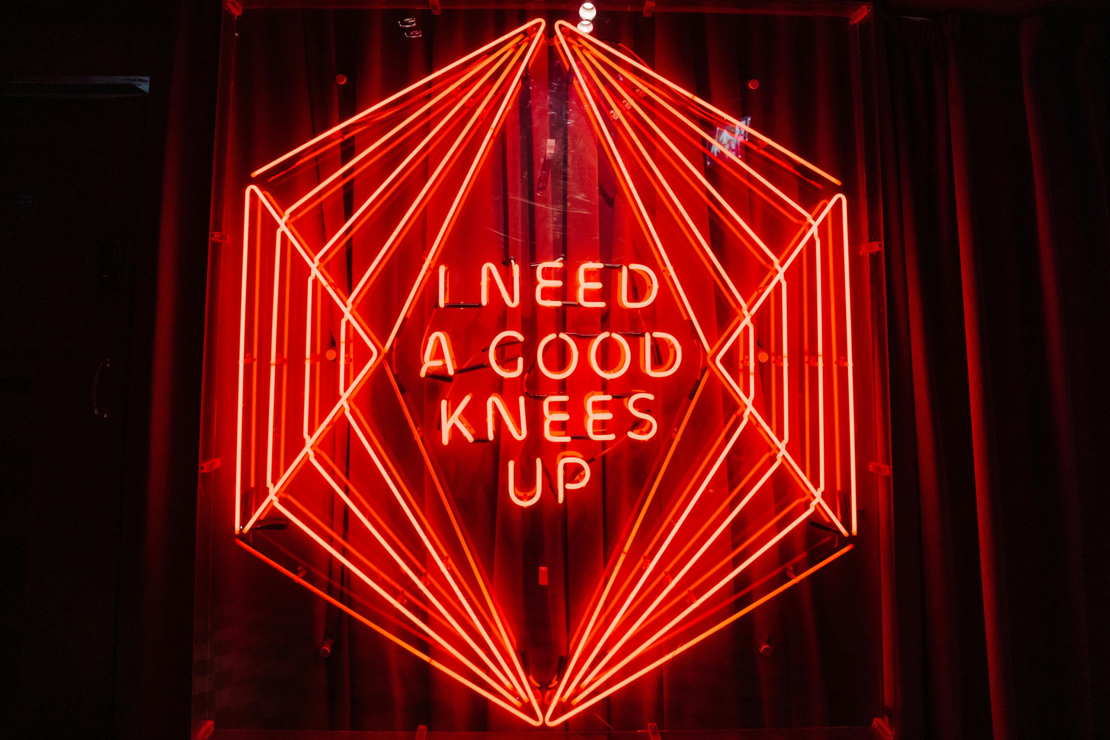 Neon sign saying I need a good knees up